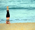 Woman standing on her head and doing yoga on the beach Royalty Free Stock Photo