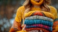 Woman Holding Stack of Knitted Sweaters