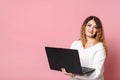 Woman standing isolated on a pink background using a laptop computer Royalty Free Stock Photo