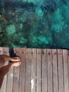 Woman standing on the jetty with beautiful clear water from the surface in Mabul Island, Semporna. Tawau, Sabah. Malaysia. Royalty Free Stock Photo