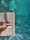 Woman standing on the jetty with beautiful clear water from the surface in Mabul Island, Semporna. Tawau, Sabah. Malaysia. Royalty Free Stock Photo