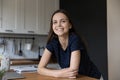 Woman standing in kitchen leaned at table staring at camera Royalty Free Stock Photo