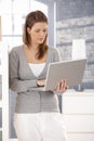 Woman standing with laptop at home Royalty Free Stock Photo