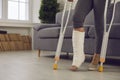 Woman standing with metal medical elbow crutches and showing broken injured leg Royalty Free Stock Photo