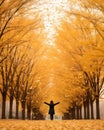 a woman standing in the middle of an autumn tree lined road