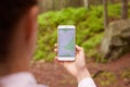 Woman standing in middle of nowhere, using navigation app on smartphone, following route with help of map, looking at device
