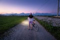 Woman is standing with mountain bike on gravel road at night Royalty Free Stock Photo
