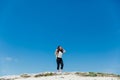 a woman standing on a mountain under a blue sky hiking journey