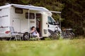 Woman is standing with a mug of coffee near the camper RV. Royalty Free Stock Photo