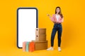 Woman Standing Near Big Phone And Cardboard Boxes, Yellow Background Royalty Free Stock Photo