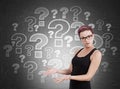 Woman standing near blackboard with question marks Royalty Free Stock Photo