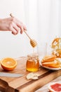 Woman standing near table with citruses and holding honey. Royalty Free Stock Photo