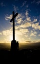Woman standing next to cross at sunset in Bray Head, Ireland Royalty Free Stock Photo
