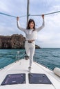 Woman standing on the nose of the yacht at a sunny summer day, breeze developing hair, beautiful sea on background Royalty Free Stock Photo