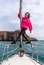 Woman standing on the nose of the yacht at a sunny summer day, breeze developing hair, beautiful sea on background Royalty Free Stock Photo