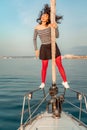 Woman standing on the nose of the yacht at a sunny summer day, breeze developing hair, beautiful sea on background Royalty Free Stock Photo