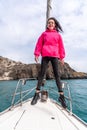 Woman standing on the nose of the yacht at a sunny summer day, breeze developing hair, beautiful sea on background Royalty Free Stock Photo