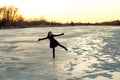 Woman Standing on One Leg on the Ice on the Frozen Platte River in Winter at Sunset Royalty Free Stock Photo