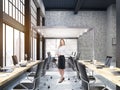 Woman standing in open office with glass board room in New York