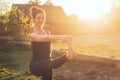 Woman standing outdoors meditating in yoga position. Royalty Free Stock Photo