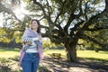 A woman is standing in a park, wearing a scarf and a white shirt Royalty Free Stock Photo