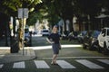 A woman is standing on a pedestrian crossing on a quiet street. Royalty Free Stock Photo