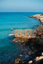 Woman standing on pier near rough stones and waving sea Royalty Free Stock Photo