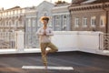 Woman standing in pose on mat and practicing yoga, female meditating outdoors Royalty Free Stock Photo