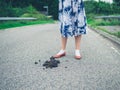 Woman standing in road by horse dung Royalty Free Stock Photo