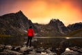 Woman Standing on a Rock at an Alpine Lake surrounded by Rugged Mountains Royalty Free Stock Photo