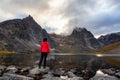 Woman Standing on a Rock at an Alpine Lake surrounded by Rugged Mountains Royalty Free Stock Photo