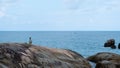 A woman standing on the rock by the seashore Royalty Free Stock Photo