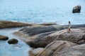 A woman standing on the rock by the seashore Royalty Free Stock Photo