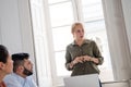 Woman standing in a room chairing a meeting Royalty Free Stock Photo