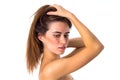 Woman standing sidewise and fixing hair