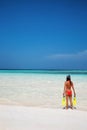 Woman standing with snorkeling gear on the beach