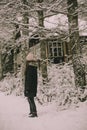 Woman standing in the snow covered park alley.Winter landscape shot.