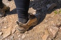 A woman standing in specialized, leather, mountain climbing shoes on a stony, slate surface.