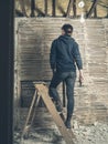 Woman standing on stepladder by wattle and daub wall Royalty Free Stock Photo