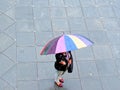 Woman carrying colorful umbrella - rainbow colors - monsoon scene - rainy season Royalty Free Stock Photo