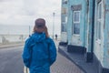 Woman standing in street outside blue house