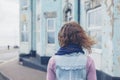 Woman standing in street outside blue house