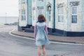 Woman standing in street outside blue house Royalty Free Stock Photo