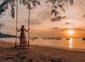 Woman standing on a swing on the beach in Thailand, Koh Tao watching sunset Royalty Free Stock Photo