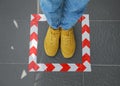 Woman standing on taped floor marking for social distance. Coronavirus pandemic