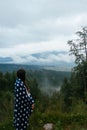 Woman standing on top of a hill, against the background of a valley Royalty Free Stock Photo