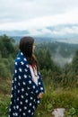 Woman standing on top of a hill, against the background of a valley Royalty Free Stock Photo