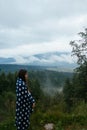 Woman standing on top of a hill, against the background of a valley Royalty Free Stock Photo