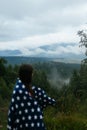 Woman standing on top of a hill, against the background of a valley Royalty Free Stock Photo