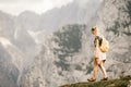 Woman standing at the top of the hill in mountains looking at wonderful scenery. Triglav, the highest slovenian mountain. Trgilav